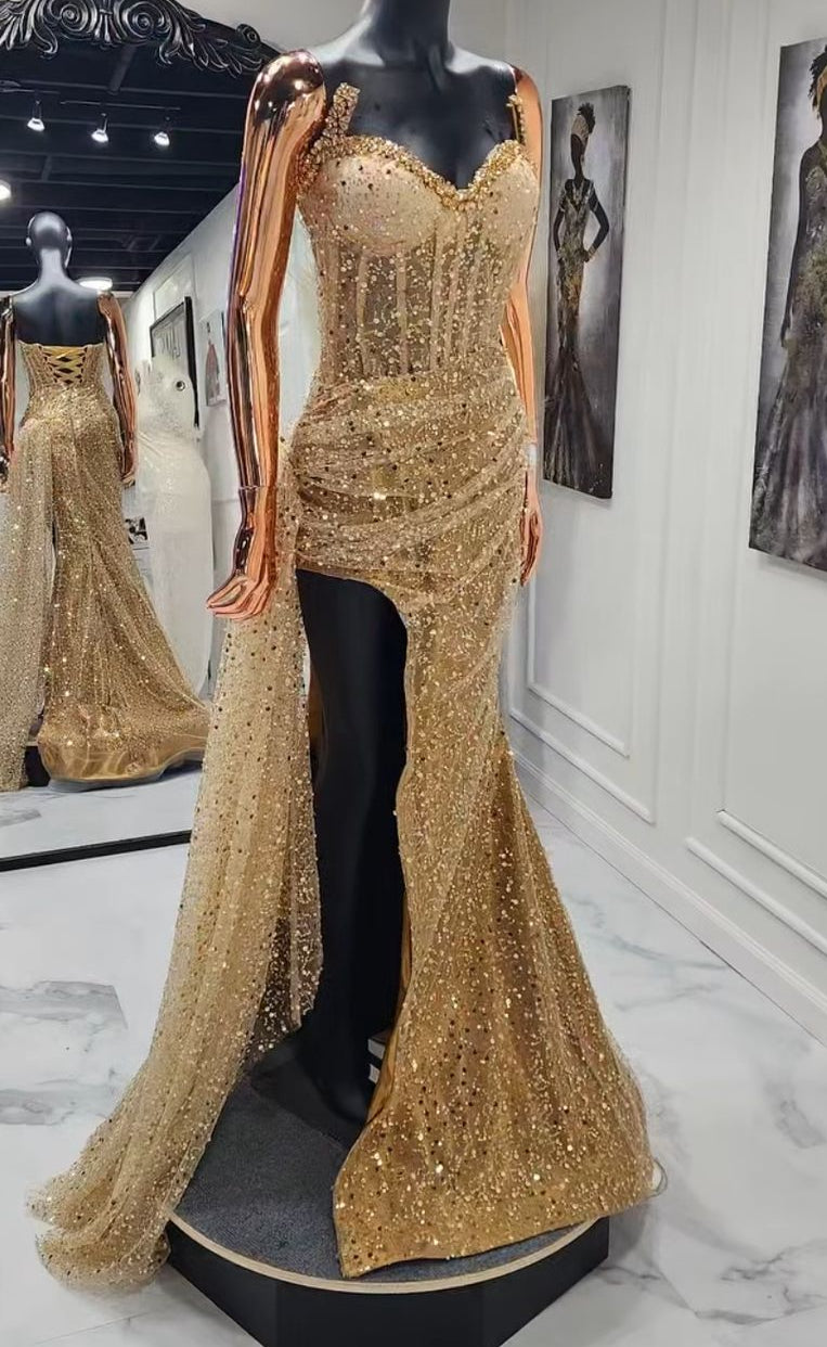 Gold evening gown on a mannequin in an exhibition setting.
